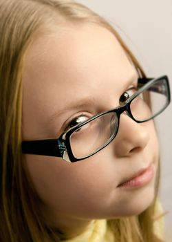 Little girl with glasses keeping an eye contact