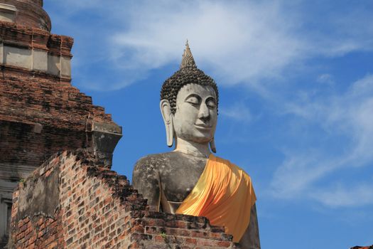 Ancient buddha statue with blue sky, Wat Yai Chaimongkol, Ayutthaya, Thailand.