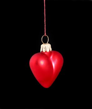 Hanging Christmas red heart  isolated on black background