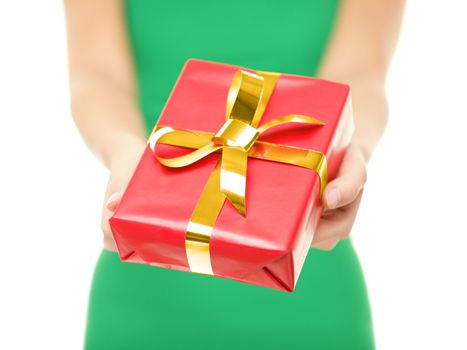 Gift. Woman giving red christmas gift / present. Closeup of woman holding and showing red Christmas present with gold ribbon on pure white background.