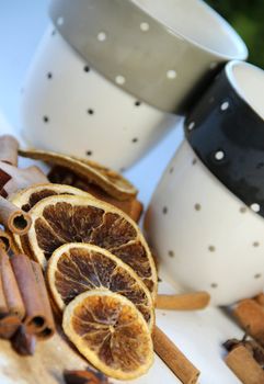 Tea, cinnamon sticks, dry orange and two cups