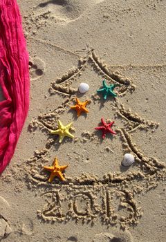 Funny beach Christmas tree decorated with the sea stars and shells