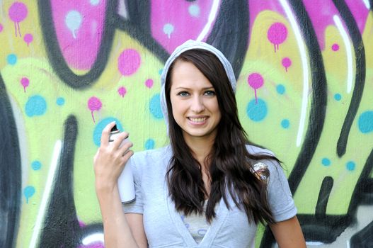 Young and beautiful girl posing against wall with graffiti