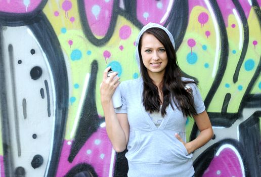 Young and beautiful girl posing against wall with graffiti