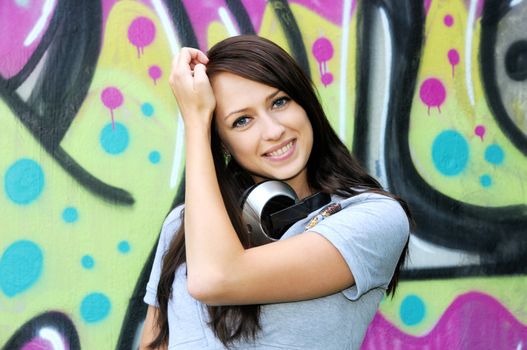 Young and beautiful girl posing against wall with graffiti