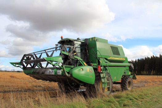 SALO, FINLAND - CIRCA OCTOBER 2012 - John Deere Harvester standing by wet field. Due to slow growth and high rainfall in autumn, some crops are lost.