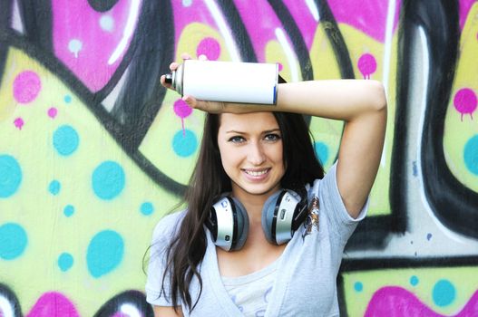 Young and beautiful girl posing against wall with graffiti