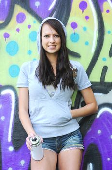 Young and beautiful girl posing against wall with graffiti