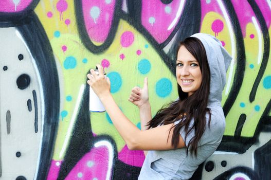 Young and beautiful girl posing against wall with graffiti