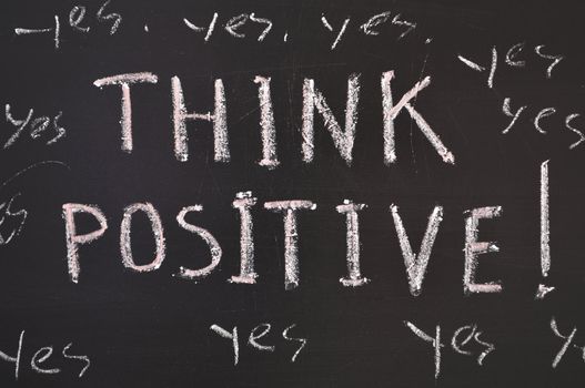 think positive concept handwritten on black chalkboard