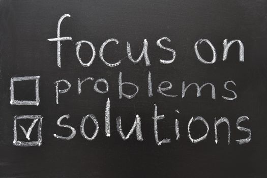 focus on solutions concept, handwritten on blackboard