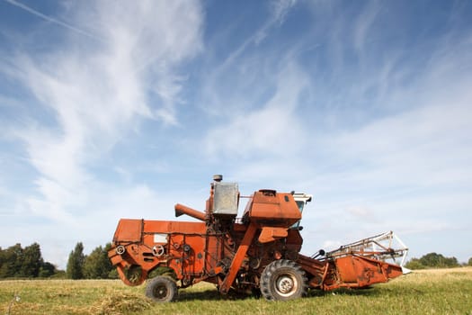 old grain harvester working in a field