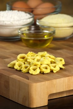 beautiful fresh raw tortellini and ingredients on kitchen wood station 