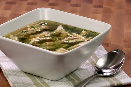 chicken breast and vegetables soup  made with low sodium  broth,  on fine wood table table.