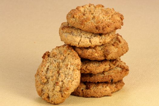 Fresh baked Stack of warm oatmeal  cookies on fine tablecloth made of linen, shallow DOF