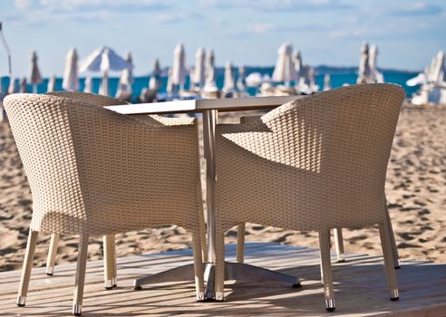 Table and wicker chairs beach cafe.