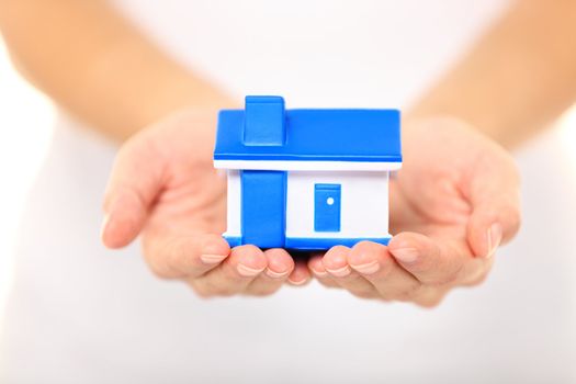 Home - new house concept. Woman holding model house