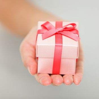 Gift closeup. Red present of gift in closeup in woman hand.