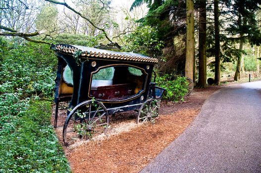 Broken-old coach hearse with the coffin being in the wood .