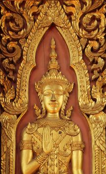 Close up ancient golden carving wooden door of temple in Ayutthaya, Thailand