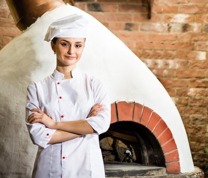 portrait of a cook, is on the traditional kitchen, crossed her arms