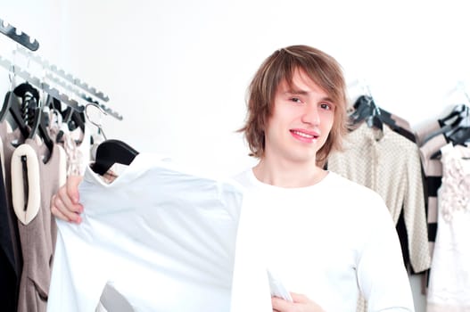 man in shop of clothes, smiles and is happy with purchases