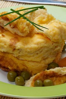 Fluffy Omelet  with Green Peas and Spring Onion on Green Plate closeup 