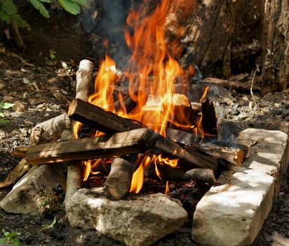 Camping Fire into Stones closeup outdoors