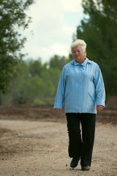 Senior women walking on a path .