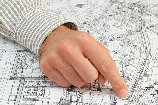 architect pointing with his finger at the solution on a very messy construction plan