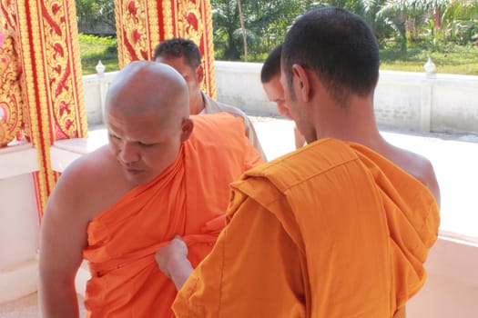 NAKON SI THAMMARAT, THAILAND - NOVEMBER 17 : The senior monk dress the new monk in the Newly Buddhist ordination ceremony on November 17, 2012 in Nakon Si Thammarat, Thailand.