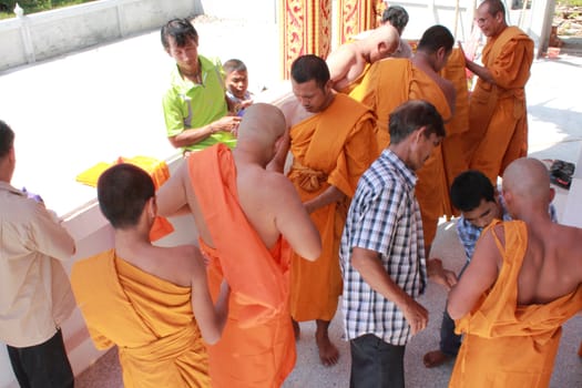 NAKON SI THAMMARAT, THAILAND - NOVEMBER 17 : The senior monk dress the new monk in the Newly Buddhist ordination ceremony on November 17, 2012 in Nakon Si Thammarat, Thailand.