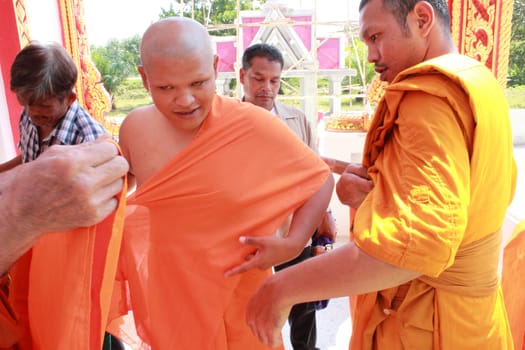 NAKON SI THAMMARAT, THAILAND - NOVEMBER 17 : The senior monk dress the new monk in the Newly Buddhist ordination ceremony on November 17, 2012 in Nakon Si Thammarat, Thailand.
