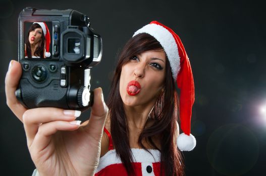 Portrait of funny Santa Claus girl with Camera