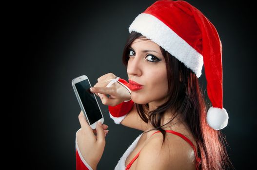 Portrait of beautiful sexy girl wearing santa claus clothes with smartphone