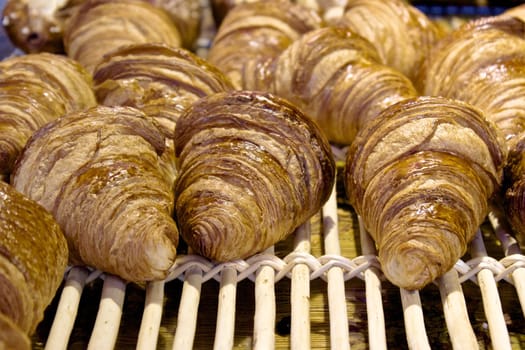 Freshly baked croissants on a wooden grid