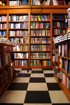 Wooden bookshelf with ledger and black and white tile floor