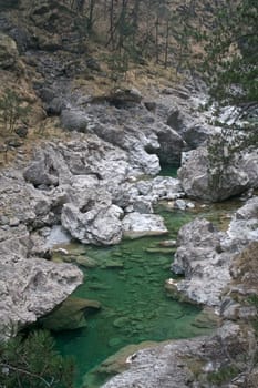 Stream of green color running between rocks