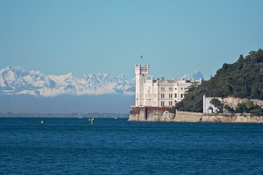 White castle with snow mountains in the background