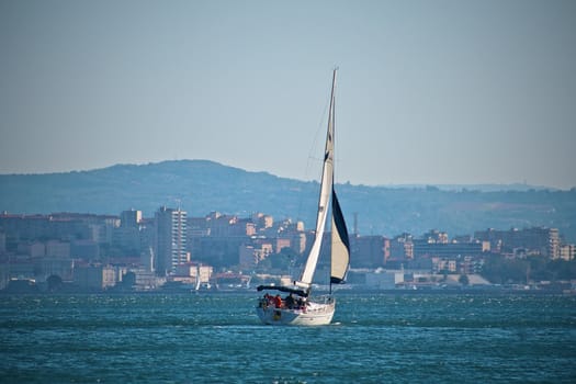 Sailing boat with city in background