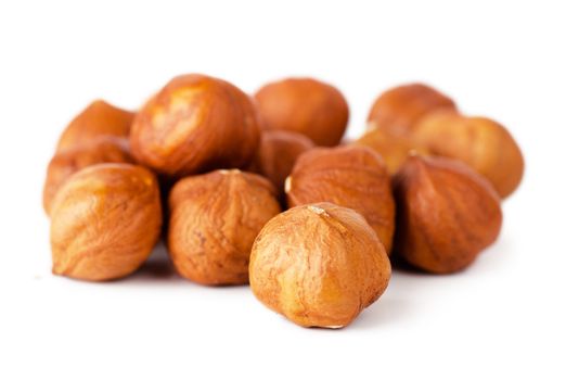 Closeup view of hazelnuts over white background