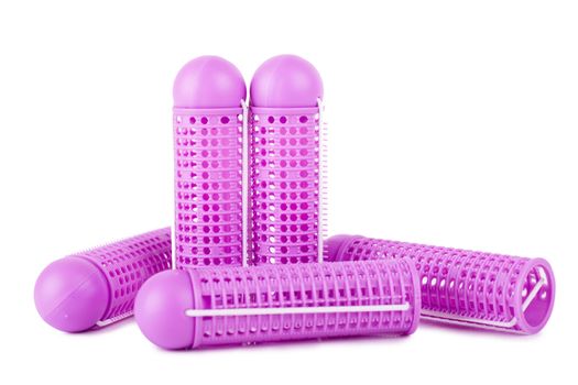 Closeup view of pink hair curlers over white background