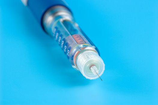 Insulin pen on a blue background