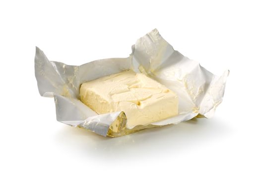 Creamy butter in its unwrapped foil paper. Isolated on white (Path)