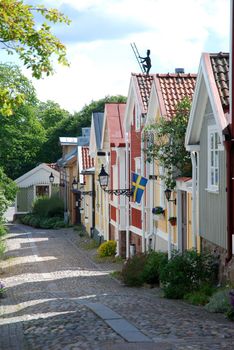 Picturesque small wooden buildings following a cobbled Street