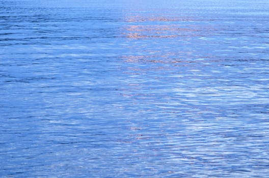 A blue water surface that flared up in evening light