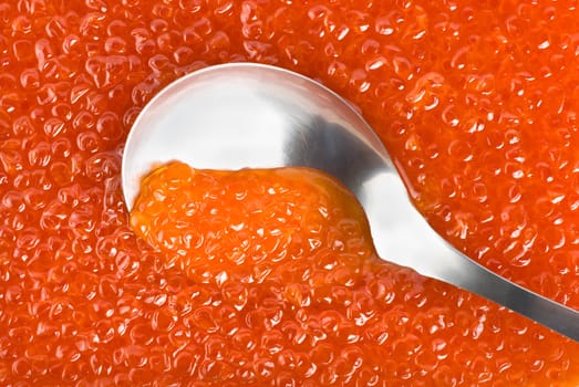 Stainless steel spoon in the red caviar