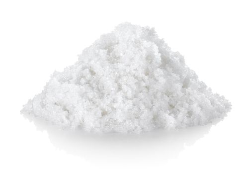 Heap of white processed granulated sugar, isolated on a white background.