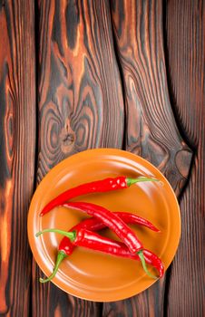 Pepper in a plate on a wooden background