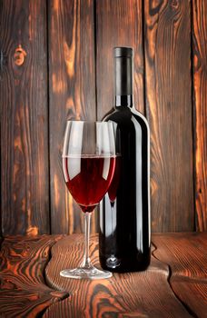 Red wine with a wine glass on wooden background